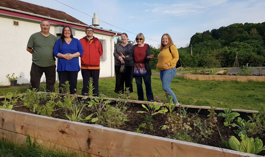 volunteers from the fruit bowl community stood beside a raised flower bed