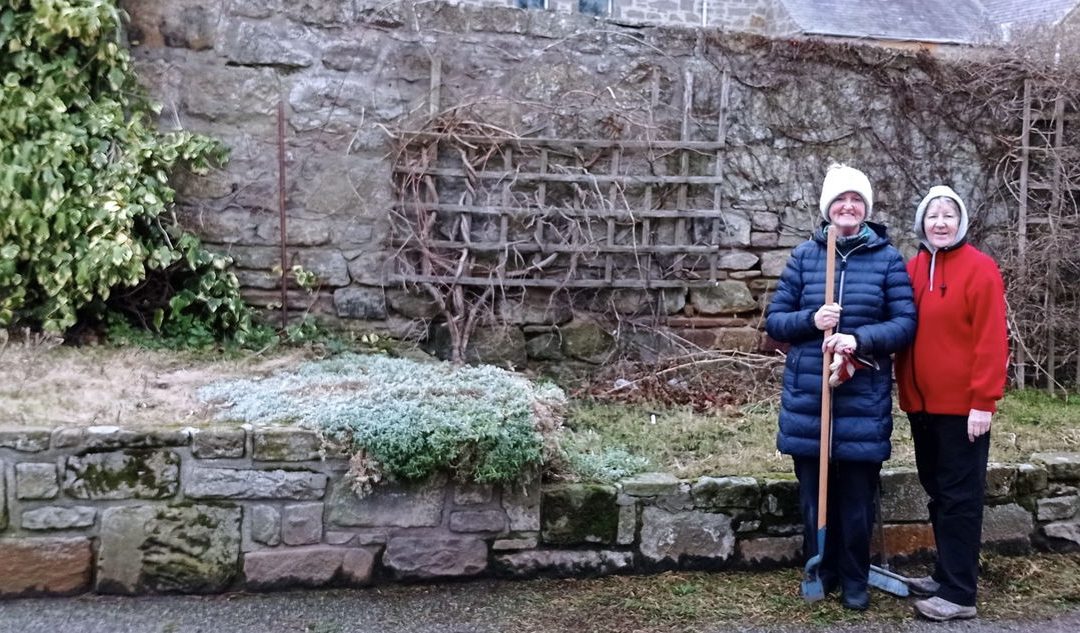 two volunteers from the hopeman community association stood next to their prepared bed for flowers to be planted
